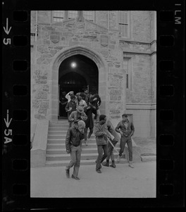 Students leaving Gasson Hall at Boston College during sit-in and hiding their faces