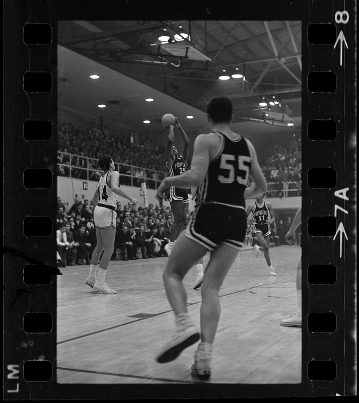 Providence College basketball player (no. 25) coming up for shot during game against Boston College