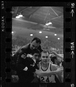 Boston College basketball coach Bob Cousy in a huddle with players
