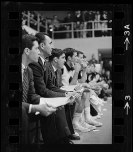 Boston College basketball coach Bob Cousy sitting on the bench with other team members during a game against Providence College