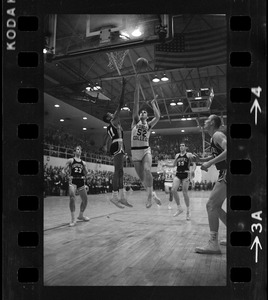 Boston College player (no. 52) and Providence College player (no. 11) both reaching for the ball during basketball game