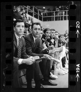 Boston College basketball coach Bob Cousy sitting on the bench with other team members during a game against Providence College