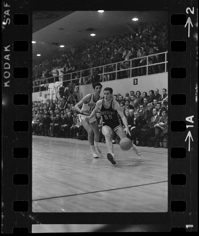 Providence College player (no. 55) with possession of the ball during a basketball game against