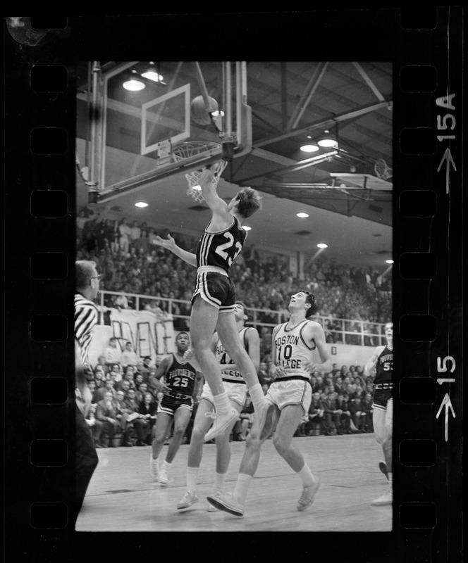 Providence College basketball player (no. 23) jumping to the basket during a game against Boston