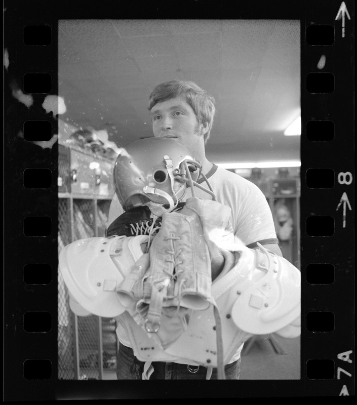 Boston College football player holding helmet, pads and gear Digital