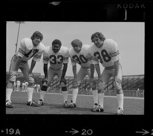 Boston College quarterback Joe Pandolfo (no. 17), far left, and co-captain Dave Bucci (no. 38), far right, pose with two other Boston College football players (no. 33 and no. 30)