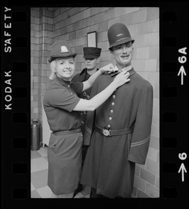 Female police officer poses with a male mannequin in police uniform