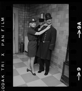 Female police officer poses with a male mannequin in police uniform