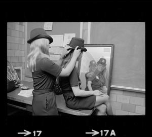 Female police officer adjusting Irish derby police cap in mirror