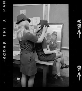 Female police officers adjusting Irish derby police cap in mirror