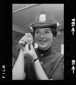 Newton's prettiest uniformed officer is Patricia MacMaster, 24, who shows her badge of authority and Irish derby cap