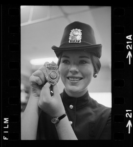 Newton's prettiest uniformed officer is Patricia MacMaster, 24, who shows her badge of authority and Irish derby cap
