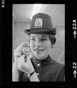 Newton's prettiest uniformed officer is Patricia MacMaster, 24, who shows her badge of authority and Irish derby cap