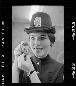 Newton's prettiest uniformed officer is Patricia MacMaster, 24, who shows her badge of authority and Irish derby cap