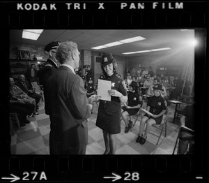 Mayor Kevin White and unidentified woman talk on stage in front of first female class of police officers