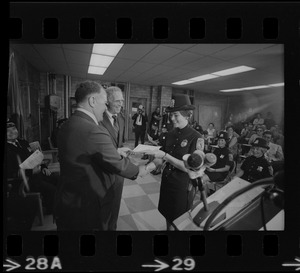 Mayor Kevin White stands by while a graduate of first female class of police officers receives her diploma