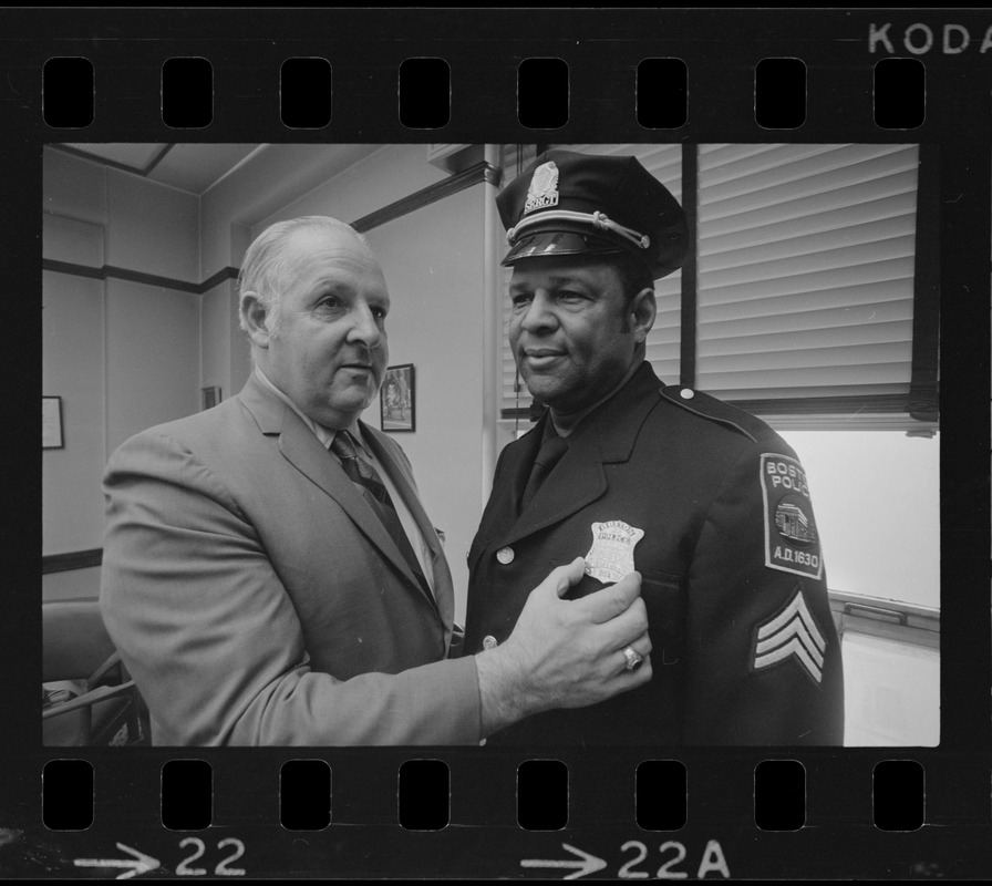 Police Comr. Edmund McNamara pins lieutenants badge on newly promoted Leroy B. Chase Jr.