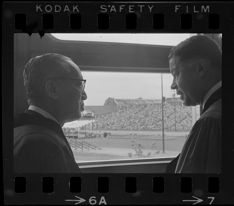 U.N. Secretary General U Thant and Senator Edward W. Brooke talking in front of window overlooking Nickerson Field during Boston University commencement