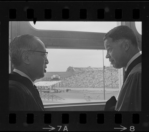 U.N. Secretary General U Thant and Senator Edward W. Brooke talking in front of window overlooking Nickerson Field during Boston University commencement
