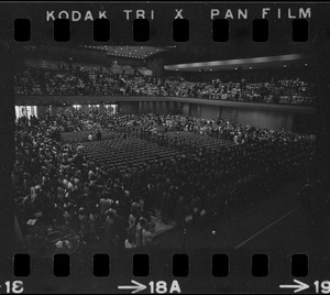 Graduates entering and filling seats during Boston University summer commencement exercises at the War Memorial Auditorium