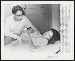 Stroudsburg, PA. Candlelight delivery--Dr. George Pettis, of Reading, Pa., is shows with Mrs. Raymond Simpson, of Stroudsburg, and her infant son Raymond Jr., who Dr. Pettis delivered by candlelight in the nursery of the Methodist Church, which was turned into an emergency shelter because of post-flood conditions.