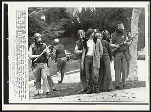 And Rocks Fell Around Them -- While one police officer gets set to fire a tear gas canister, other hold two youths in custody as rocks fly around them during a confrontation after an anti-war rally on the University of California at Berkeley campus Wednesday.