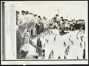 Placing Their Flags--Participants in Honor America Day observances in Washington place small American flags in sand on the Ellipse today. The Washington Monument is in the background.