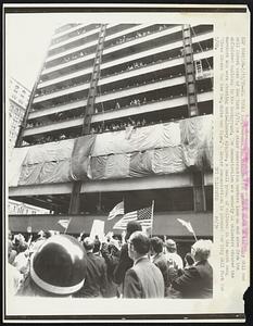 Longshoremen and construction workers march on the City Hall and Wall Street area of New York 5/15, as other construction workers look on and wave from the unfinished-building in the background. The demonstration was orderly as onlookers cheered the marchers who were chanting anti-Lindsay slogans. A small group of children in the march sang "Three Cheers for the Red, White and Blue." A larger demonstration is planned for City Hall Park for 5/20
