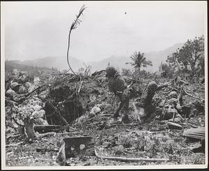 Marines on Saipan, protected by a small bank, lob grenades at the Japanese positions