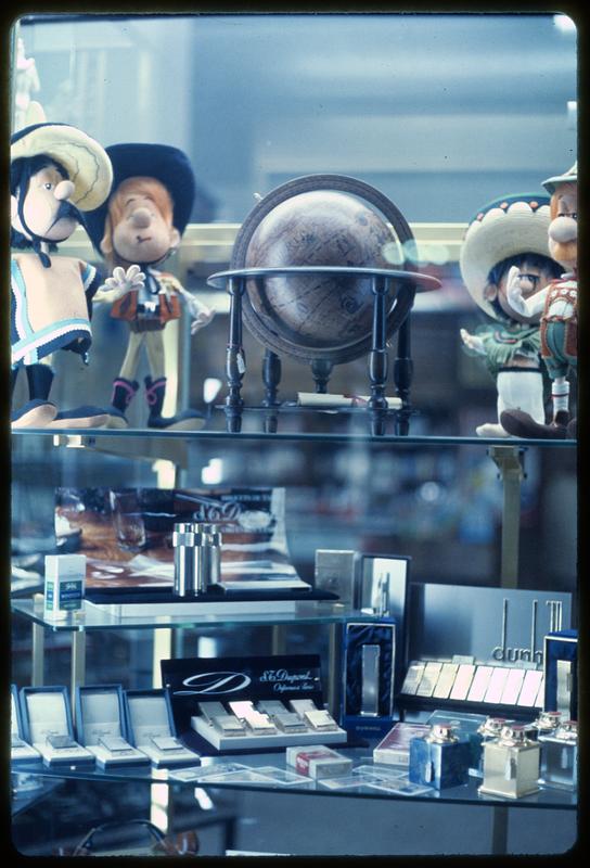 Merchandise display with dolls and lighters, likely Roma Termini train station in Rome