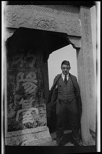 Man next to stone carving