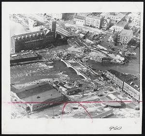 Waterbury Flood Havoc - Air view shows splintered railroad bridge next to American Brass Company plant in Waterbury, Conn., after flood waters swept through industrial city.