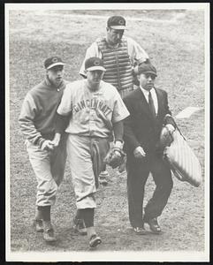 To the Showers Paul Derringer (center) Cincinnati Reds' hurler, heads for the dugout after Bill Dickey Yankee catcher, had driven in the winning run in the ninth inning of the first game of the World Series between the Yanks and Reds at New York, Oct. 4. Bucky Walters (left) who is slated to pitch the second game of the series against the ... Yanks, October 5, offers words of comfort to the loser of a pitching duel with Red Ruffing of the Yanks. Behind Derringer is Ernie Lombardi, his battery mate and at the right is Umpire Bill McGowan.