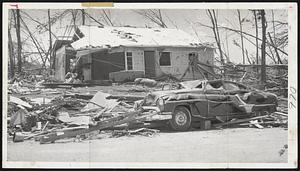 Tornado Street Scene-for a wide stretch in the tornado belt you could see scenes like this of the battering which struck houses and cars just as many persons has arrived home from the day's work. This scene is from the Winthrop Oaks section of Holden.