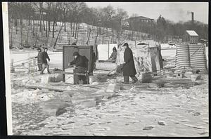 Fishing-The Hard Way- not worried about the fuel shortage are these hardy fisherman (right) who, protected from 18 inches of ice to fish for smelts in the Neponset river Milton. At left: Vincent E. Cahill of Wollaston, lifts his pole and would be "Brrrrr," but the fisherman seem to like it.