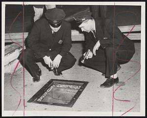 Dry Sewer--Police inspect 10-foot deep sewer shaft in which a Lawrence woman was injured when she dropped into an open manhole in the dark on Beverly street at the approach of the Warren street bridge. Shown above are her rescuers' Patrolmen Kenneth Thistle and John J. Walsh.