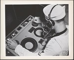A radarman aboard the navy cruiser USS Augusta eyes the scope of the ship's radar