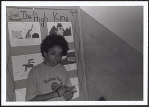 Boy standing in front of a book project display