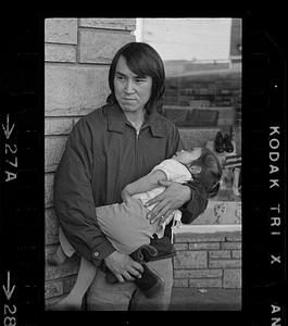 A man holds a sleeping toddler, Alaska