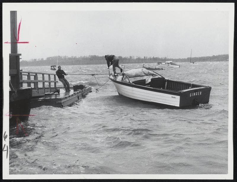 Workmen at Kehoe's Landing, Hingham, battle to pull boat to safety from pounding surf caused by Hurricane Ginny.