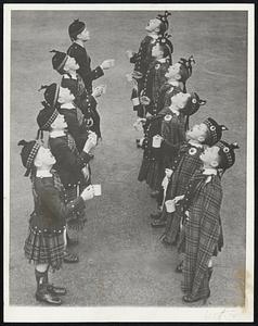 Thousands of people in London have fallen victims of an influenza epidemic. Boy pipers at an orphans' home are shown at their early morning gargling in their contribution to halt the epidemic.