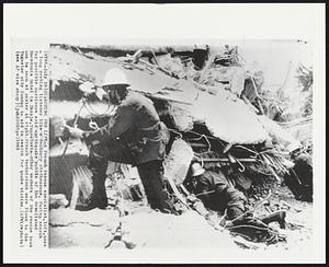 Searching For LIfe -- A French rescue specialist, left, uses a long probing listener like a doctor's stethoscope, during search for possible survivors amid earthquake rubble of the demolished Macedonia Hotel in Skopje, Yugoslavia. Other members of the rescue team can be seen at center at right. French technicians were flown to the Yugoslav city Sunday to aid in search for quake victims.