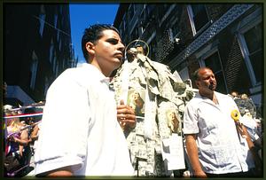 Boston 2002: Members of the Society of S. Anthony stand next to the saint's statue during a break of the procession through the city's N. End