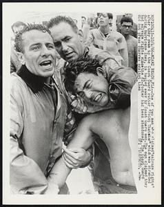 Miami Beach, Fla-- One of two men who claimed "salvage rights" after they swam to the Coast Guard cutter "Point Thar her" which was stranded during hurricane Inez, is hauled away by Coast Guard men. The men claimed they had salvage rights since the 82-footer had been abandoned. The Coast Guard did not press charges against them.