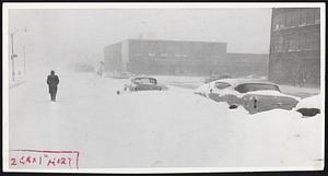 Doughty Worker Harrison Ave. today on his way to the new Herald and Traveler building, which is partially obscured by driving snowstorm. Walking obviously was no picnic.