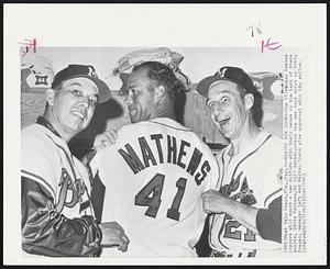 West Palm Beach, Fla. – Braves New Look – The Milwaukee Braves players will sport a new uniform with their names on the back of there shirts. Eddie Mathews, No (41) center, wears the new look shirt as Bobby Bragan, manager left and Warren Spahn give approval with big smiles.