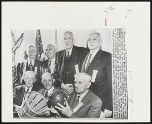 The Buffalo Germans--One of Three teams voted in to the special honor group, of The Basketball Hall Of Fame are shown looking over the Original first Basketball and Basket used in the game long ago. Standing left to right are Albert Manweiler, Philip Dischinger, Henry Miller, and his Brother Edward Miller,. Bottom Row Left to Right are Henry Foust, George Redlien, [and George Schell]