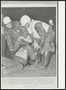 Stopping a Demonstrator - Two policemen restrain a flag decorated demonstrator during the outbreak of violence in Washington tonight. A rock-throwing crowd of demonstrators marching to the South Vietnam embassy in the nation's capitol were stopped by police with tear gas.
