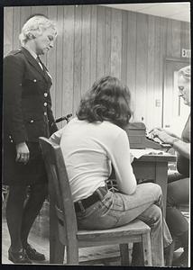 Sad scene Quincy Dope raid. Girl being booked -- Policewoman Mary Jennings + police sgt. Jim Fay -- typing