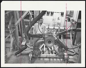 Super Magnet - Dr. Henry H. Kolm of MIT shown with magnet he invented which generates continuous magnetic field of 126,000 gauss. Earth's magnetic field, which controls compass needle, half a gauss.
